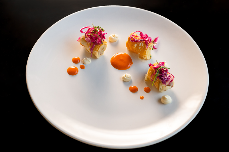Cannoli de pirogui – massa de pirogui em formato de cannoli frito por imersão, recheado com batata, ricota e linguiça crocante. Picles e repolho roxo com crem, molho bechamel e molho de pimenta.